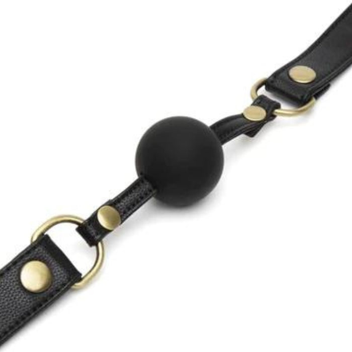 Fifty Shades of Grey Gag Ball - Bound to You Black is a durable handcrafted faux leather ball gag with a medium sized silicone ball, antique gold hardware and adjustable strap.