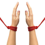 Indulge in effective restraint play with Restrain Me, a set of two silky bondage ropes, each measuring 5 meters. This image is of the red rope tied around each wrist seperately.
