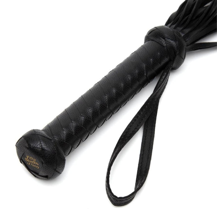 Fifty Shades of Grey Flogger/Whip - Bound to You Black is a handcrafted faux leather flogger with a wrist loop for secure play and easy storage. The tails will provide passion through gentle tickles or sharp stings. The woven handle adds stunning detailing to the look of this pleasurable bondage accessory. You won't believe the sensations and thrill of this flogger when used in your bondage adventur