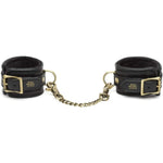 Fifty Shades of Grey Hand Cuffs - Bound to You Black are a durable, handcrafted padded faux leather hand cuffs with antique gold hardware. These cleverly designed cuffs have D-rings on each cuff for versatile bondage play and detachable chain with swivel lobster clasp at each end. This versatile set is compatible with the Bound to You spreader bar and hogtie.