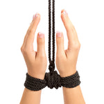 Indulge in effective restraint play with Restrain Me, a set of two silky bondage ropes, each measuring 5 meters. This image is of the black rope tied around both hands.