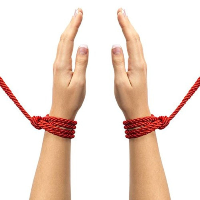 Indulge in effective restraint play with Restrain Me, a set of two silky bondage ropes, each measuring 5 meters. This image is of the red rope tied around each wrist seperately.