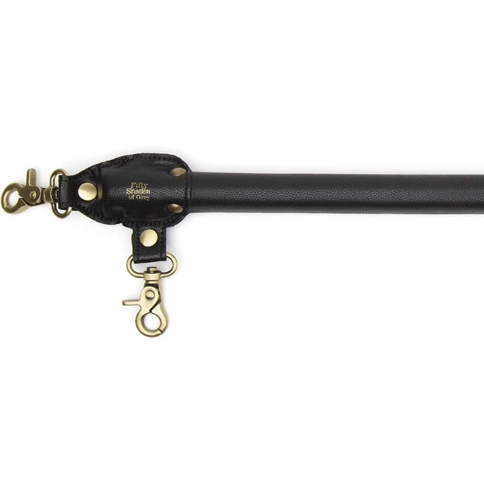 Fifty Shades of Grey Spreader Bar - Bound to You Black is a lightweight, durable and strong 50,8 cm handcrafted faux leather spreader bar with antique gold hardware. This cleverly designed bar has 4 swivel lobster clasps and is compatible with the Bound to You wrist and ankle cuffs.
