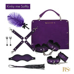 The Rianna S Kinky me softly purple handbag kit, 7 piece is the perfect accessory for the adventurous and stylish woman who loves to explore her kinky side. This set of 7 includes a feather, nipple clamps, hand and ankle cuffs that can be attached or detached from a joiner, it also includes a blindfold and flogger with wrist band. 