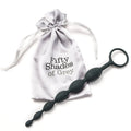 Black silicone anal beads with a handle beside Fifty Shades of Grey drawstring bag