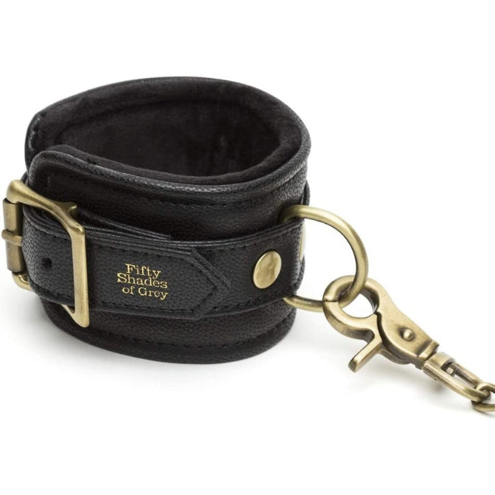 Fifty Shades of Grey Hand Cuffs - Bound to You Black are a durable, handcrafted padded faux leather hand cuffs with antique gold hardware. These cleverly designed cuffs have D-rings on each cuff for versatile bondage play and detachable chain with swivel lobster clasp at each end. This versatile set is compatible with the Bound to You spreader bar and hogtie.