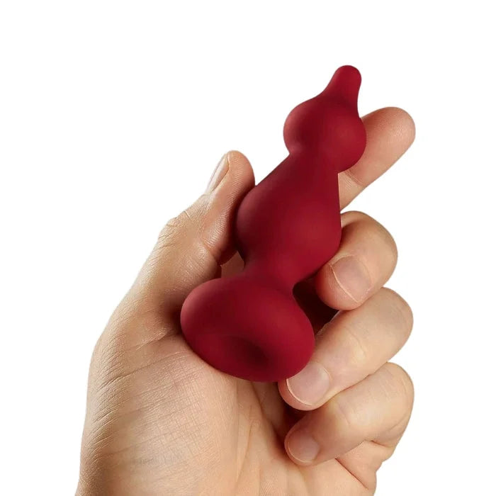 Hand holding matte red ForTo F-30 anal plug small hourglass toy
