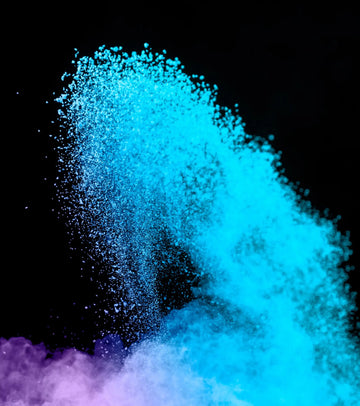 A vibrant blue powder explosion against a black background, with hints of purple at the base.